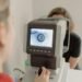 Optician performing eye examination - patient recall system
