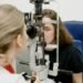 Optometrist performing a slit-lamp examination on a patient — UK independent optician practice AMD detection and monitoring.