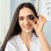 Optometrist holding a trial lens in a UK independent optician practice — clinical specialism positioning for independent practices in 2026.