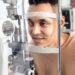 Optometrist conducting an eye examination on a patient — UK independent optician practice diabetic eye care pathway.