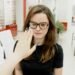 Patient trying on a tortoiseshell frame in a UK independent optician practice — the dispense moment after the optometrist-to-DO handover.