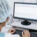 Medical professional reviewing a digital patient record on a computer in a clinical setting