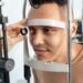 Optometrist examining a patient at the slit-lamp during an eye test — UK independent optician practice patient attendance and no-show reduction.