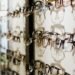 Wall-mounted display of diverse eyeglasses in an optician's store — UK independent optician practice frame stock and inventory management