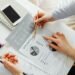 Two business owners reviewing financial charts and growth data — strategic planning for a second UK independent optician practice