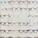 Rows of eyeglass frames displayed on glass shelves in an independent optician practice — building private dispensing revenue beyond the NHS sight test fee.