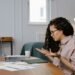 Practice manager working at a desk with a laptop in a UK independent optician practice